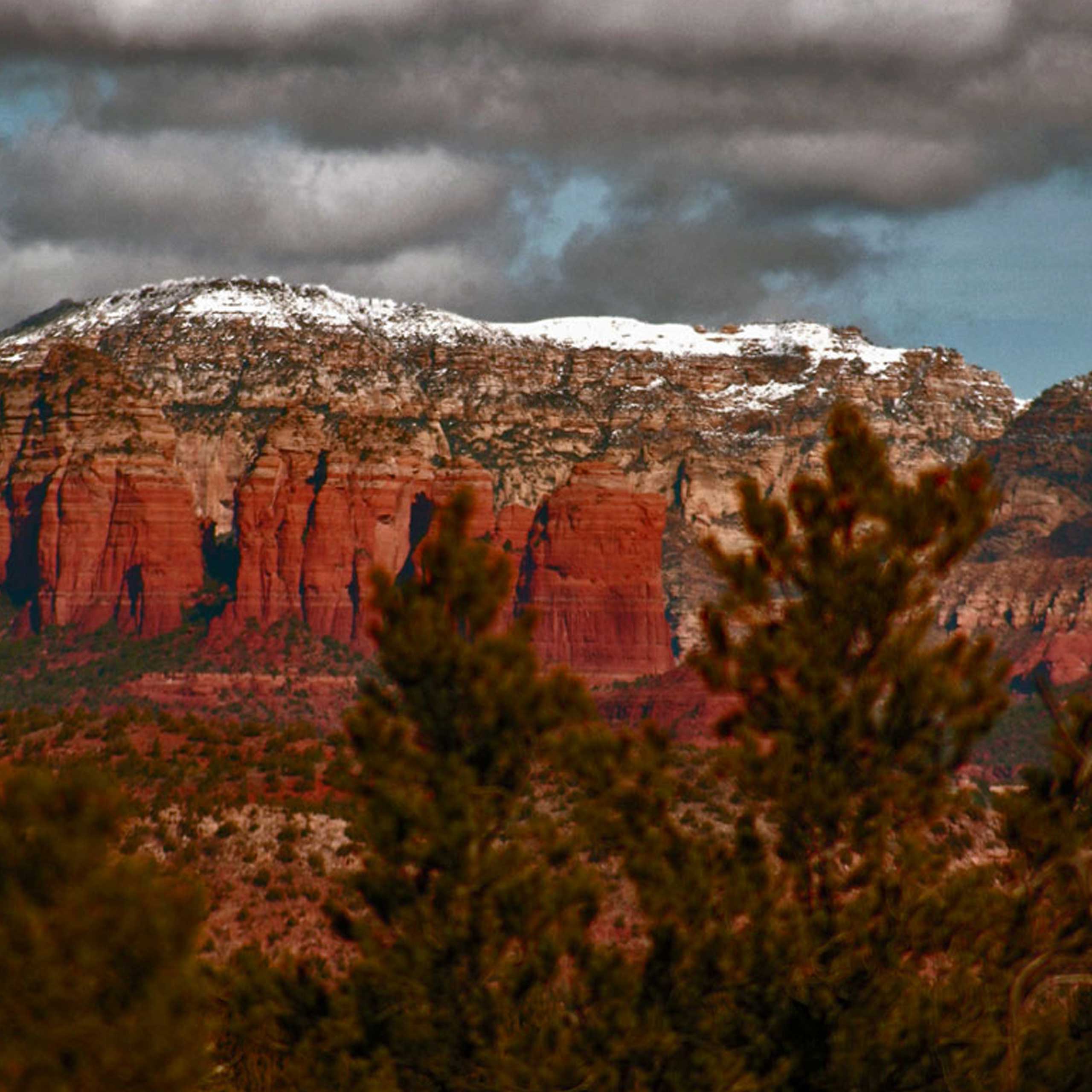 A light blanket of snow covers the distant red rock of Sedona in winter